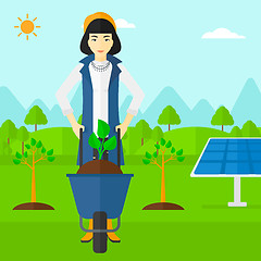 Image showing Woman with plant and wheelbarrow.