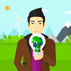 Image showing Man with lightbulb and trees inside.