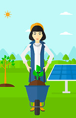 Image showing Woman with plant and wheelbarrow.