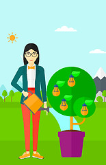 Image showing Woman watering tree with light bulbs.