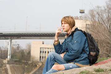 Image showing The sitting guy with a cigarette outdoor 1