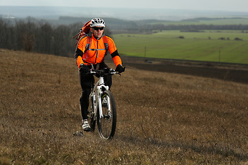 Image showing Man cyclist with backpack riding the bicycle