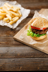 Image showing Homemade hamburgers and french fries on wooden table