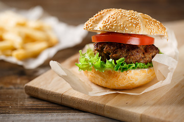 Image showing Homemade hamburgers and french fries on wooden table