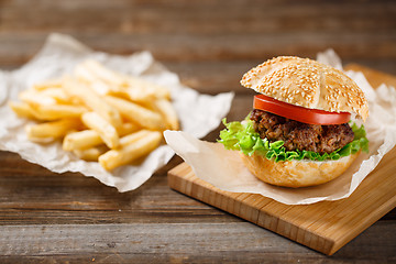 Image showing Homemade hamburgers and french fries on wooden table