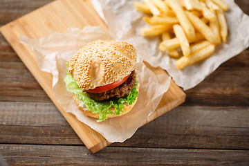 Image showing Homemade hamburgers and french fries on wooden table