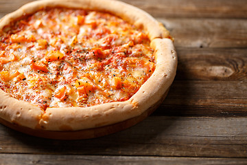 Image showing Tasty pizza on old wooden table.