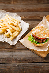 Image showing Homemade hamburgers and french fries on wooden table