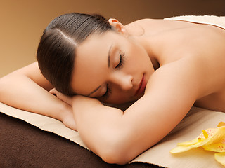 Image showing woman in spa salon lying on the massage desk