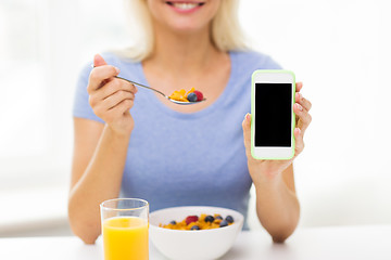 Image showing close up of woman with smartphone eating breakfast