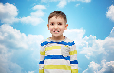 Image showing happy smiling little boy over blue sky and clouds