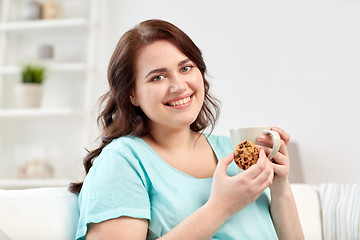 Image showing happy plus size woman with cup and cookie at home