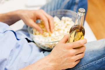 Image showing close up of man with popcorn and beer at home