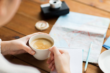 Image showing close up of hands with coffee cup and travel stuff