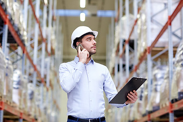 Image showing man with clipboard and smartphone at warehouse