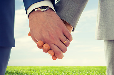 Image showing close up of male gay hands with wedding rings on