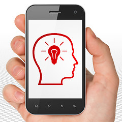 Image showing Finance concept: Hand Holding Smartphone with Head With Lightbulb on display