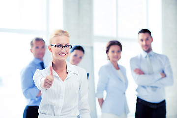 Image showing businesswoman in office showign thumbs up