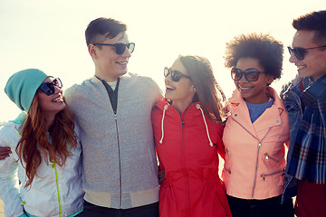 Image showing happy teenage friends in shades talking on street