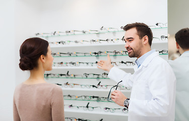 Image showing woman and optician showing glasses at optics store