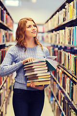 Image showing happy student girl or woman with books in library