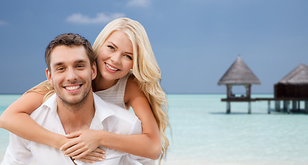 Image showing happy couple having fun over beach with bungalow