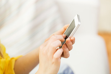 Image showing close up of hands texting on smartphone at home