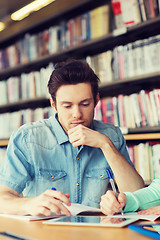 Image showing male student with tablet pc networking in library