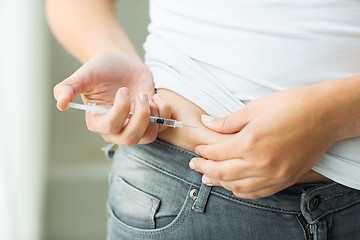 Image showing woman with syringe making insulin injection