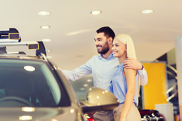 Image showing happy couple buying car in auto show or salon