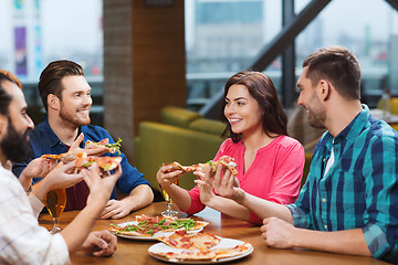 Image showing friends eating pizza with beer at restaurant