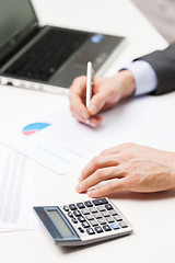 Image showing close up of businessman with laptop and papers