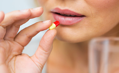 Image showing close up of woman taking medicine in pill