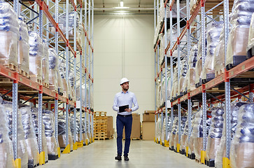 Image showing happy businessman with clipboard at warehouse