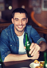 Image showing happy young man drinking beer at bar or pub