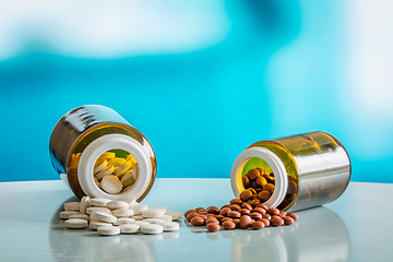 Image showing Pills on a table with two glasses