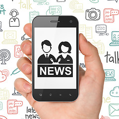 Image showing News concept: Hand Holding Smartphone with Anchorman on display