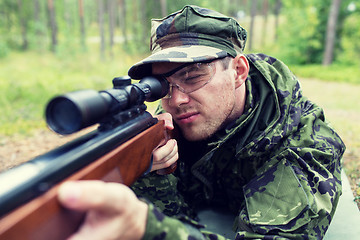 Image showing close up of soldier or hunter with gun in forest