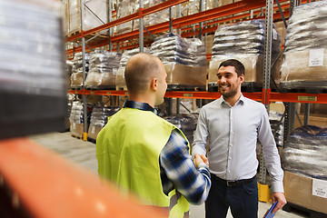 Image showing worker and businessmen with clipboard at warehouse