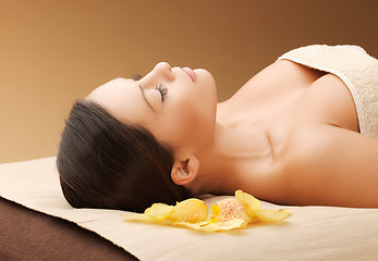 Image showing woman in spa salon lying on the massage desk