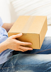 Image showing close up of man with cardboard box parcel at home