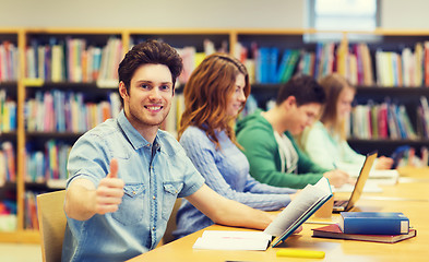 Image showing happy student boy preparing to exam in library