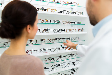 Image showing optician showing glasses to woman at optics store