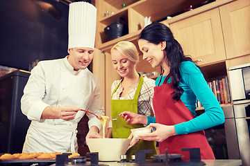 Image showing happy women and chef cook baking in kitchen