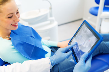 Image showing dentist with teeth x-ray on tablet pc and woman