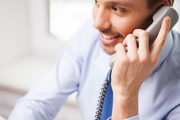 Image showing happy businessman calling on phone at office