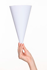 Image showing The white cone in the  female hands on white background