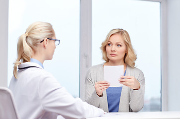 Image showing doctor giving prescription to woman at hospital