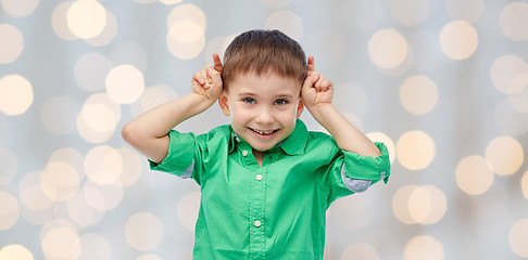 Image showing happy little boy having fun and making horns