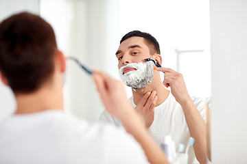 Image showing man shaving beard with razor blade at bathroom